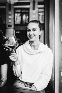 Portrait of a smiling young man drinking glass