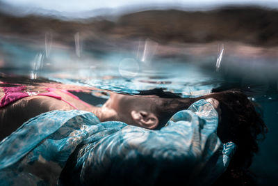 Midsection of woman lying in water