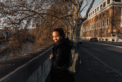 Portrait of young woman standing on street