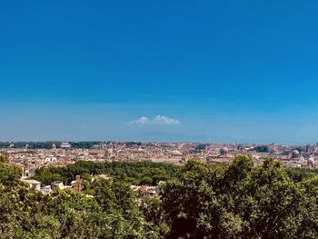 Aerial view of townscape against blue sky