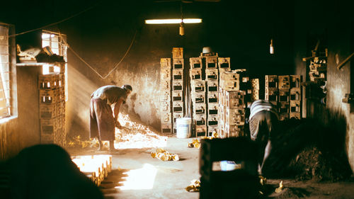 Men sweeping dusty room