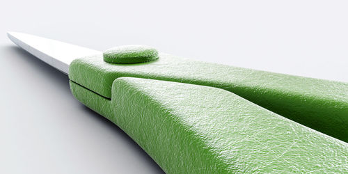 Close-up of green toy on table against white background