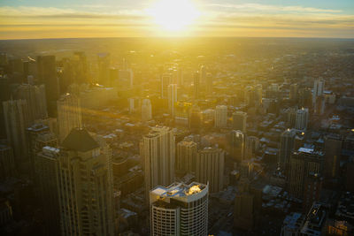 Aerial view of modern buildings against sky during sunset