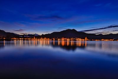 Scenic view of lake against blue sky at dusk
