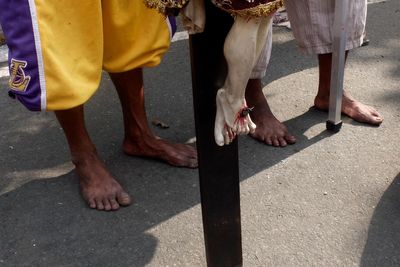 Low section of people with crucifix on street