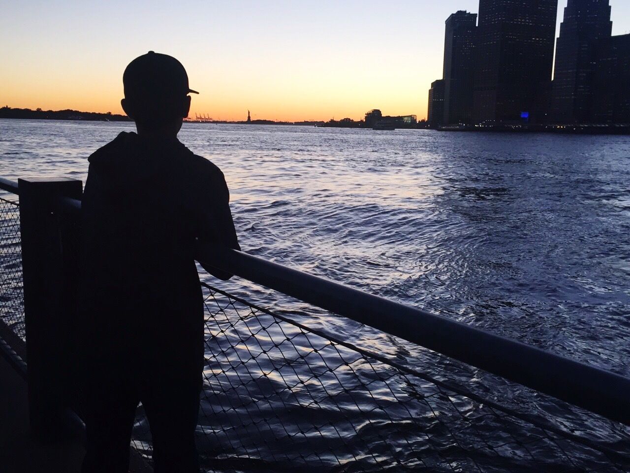 REAR VIEW OF SILHOUETTE MAN STANDING BY SEA AGAINST SKY