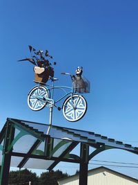 Low angle view of bicycle against clear blue sky