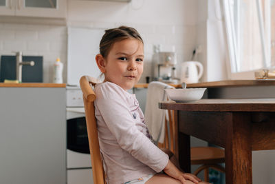 Portrait of cute girl sitting at home