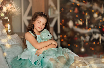 Cute girl sitting on christmas tree