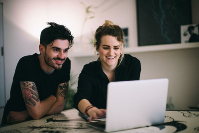 Young couple sitting on table at home