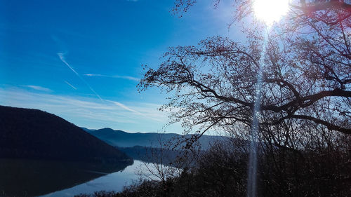 Scenic view of lake and mountains against blue sky