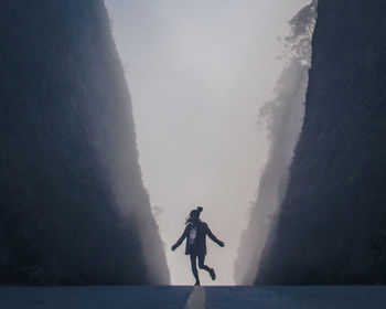 Rear view of man walking on road