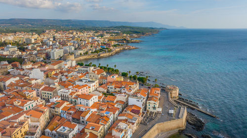 High angle view of townscape by sea against sky