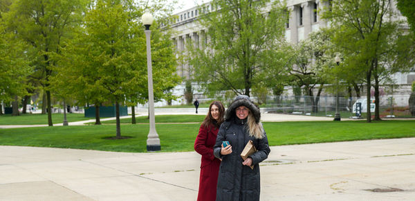 Portrait of woman standing against trees