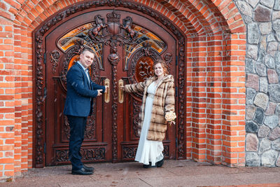 Statue of man and woman standing against wall