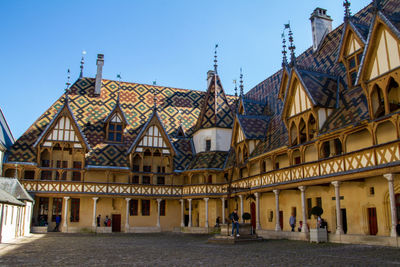 Beaune, france, april 16, 2022, flamboyant gothic style hospices with burgundy glazed tile roof.