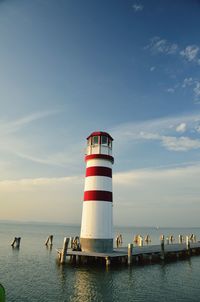 Lighthouse on shore against blue sky