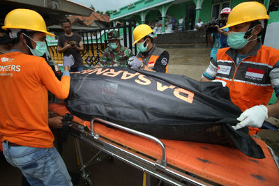 Rear view of people working on boat