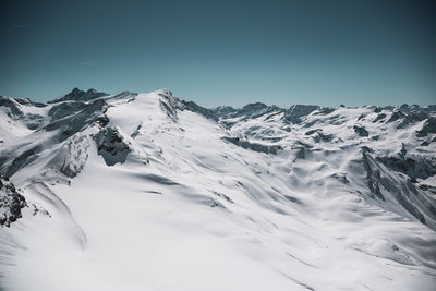 Scenic view of snowcapped mountains against clear sky