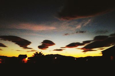 Low angle view of silhouette trees against dramatic sky