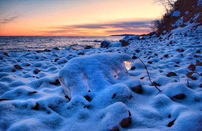 Scenic view of frozen lake against sky during sunset