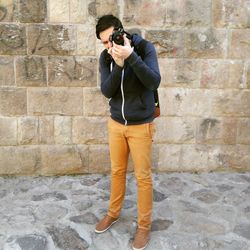 Rear view of man standing against brick wall