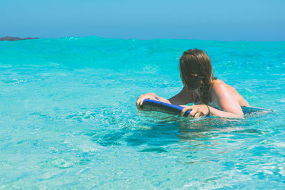 Young woman surfing in sea