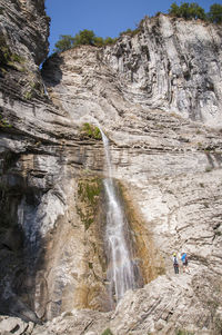 Low angle view of waterfall on cliff