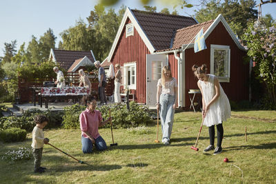 Family playing croquet in garden