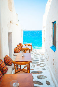 Chairs and table on beach against buildings