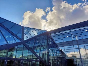 Low angle view of glass building against sky