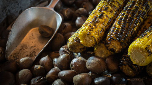 High angle view of roasted chestnuts and corn for sale in festival outdoor market