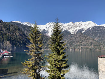 Scenic view of lake by snowcapped mountains against sky