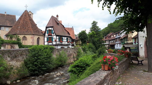 Footpath amidst houses and buildings against sky