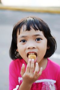 Portrait of cute girl eating food outdoors