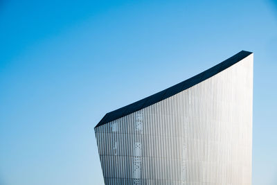 Low angle view of modern building against clear blue sky