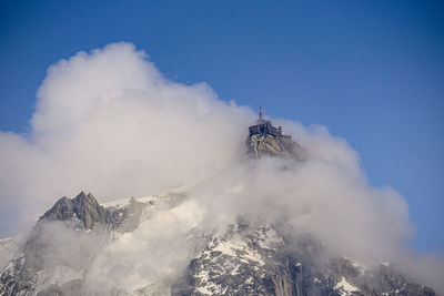 Low angle view of snowcapped mountains against sky