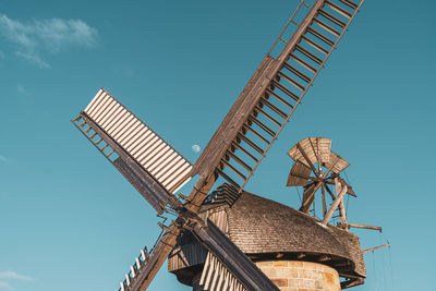 Low angle view of traditional windmill against clear blue sky