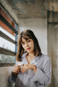 Portrait of woman standing against wall