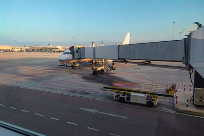 Airplane on airport runway against sky