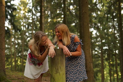 Mother and girl standing in forest