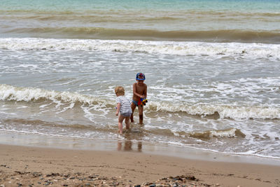 Rear view of boy running at beach