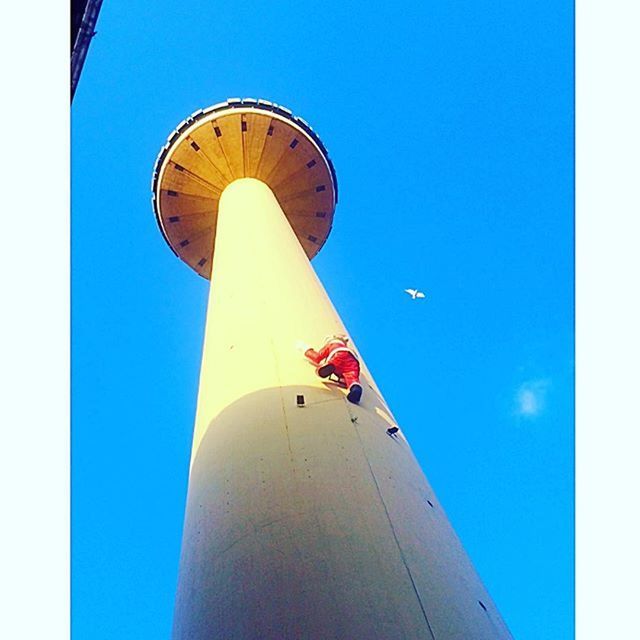 low angle view, blue, architecture, built structure, tower, building exterior, guidance, tall - high, clear sky, street light, sky, lighting equipment, communications tower, communication, lighthouse, outdoors, day, no people, pole, direction