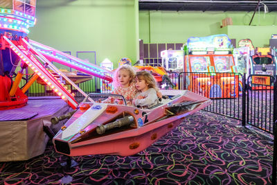 Two girls on indoor amusement park ride having fun