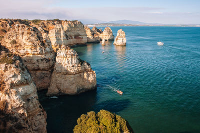 High angle view of rock formation in sea against sky