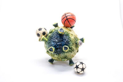 Close-up of figurine with ball against white background