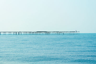 Pier over sea against clear sky