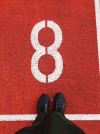 Low section of man standing on running track