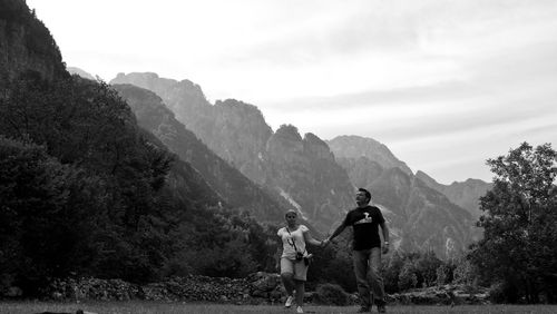 Couple walking against mountains