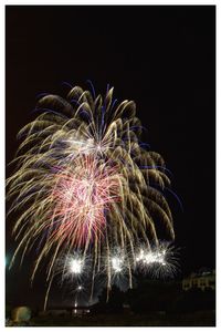 Low angle view of firework display against sky at night